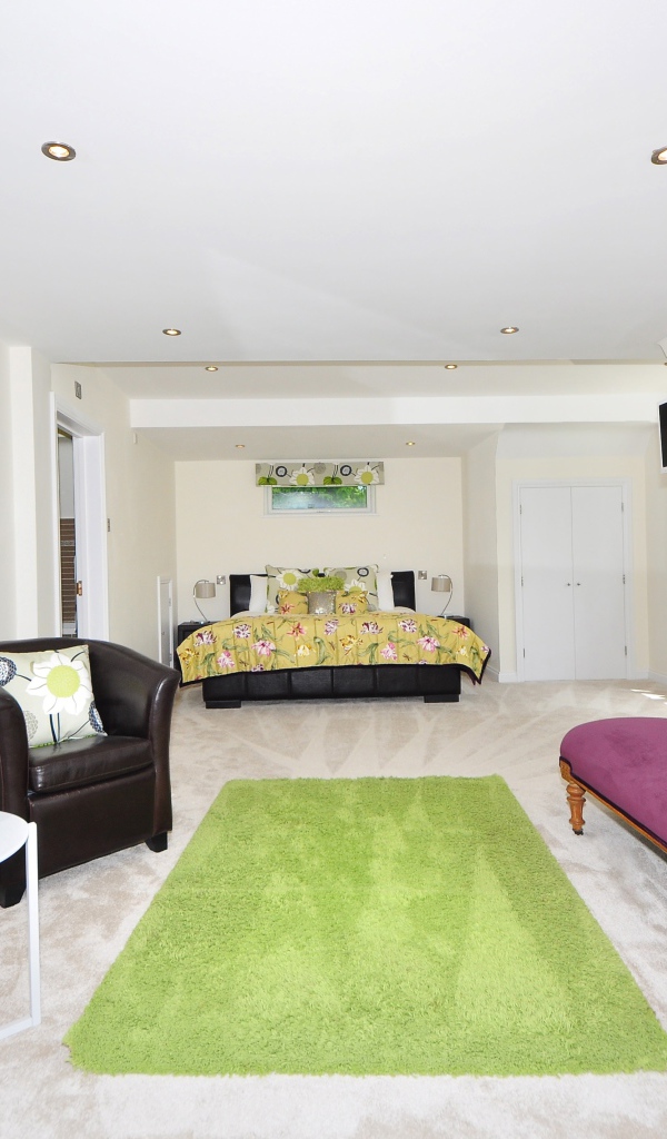 Большая гостиная с высокими белыми стенами и мебелью 