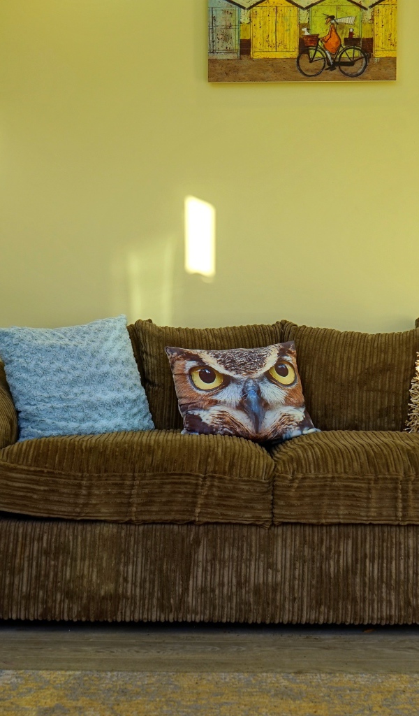 Большой старый диван в комнате с желтыми стенами