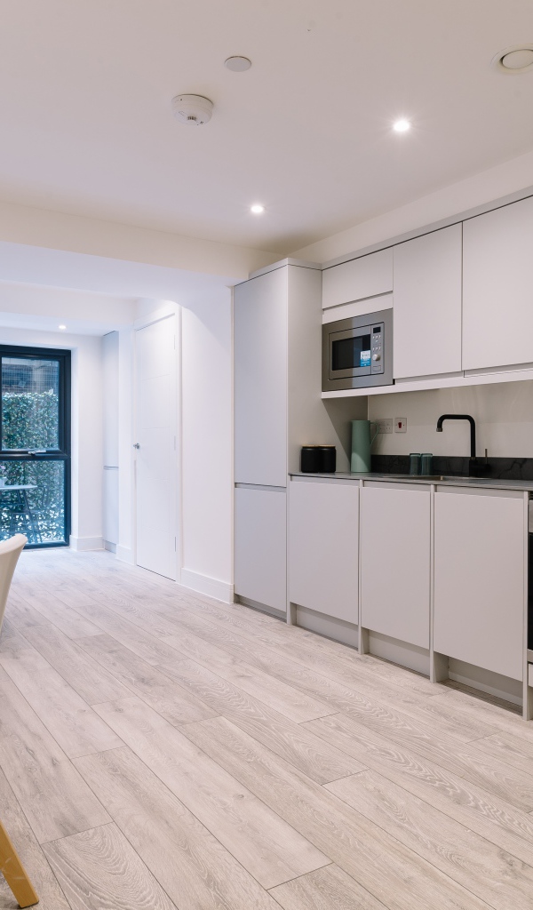 Большая просторная белая гостиная с букетом роз