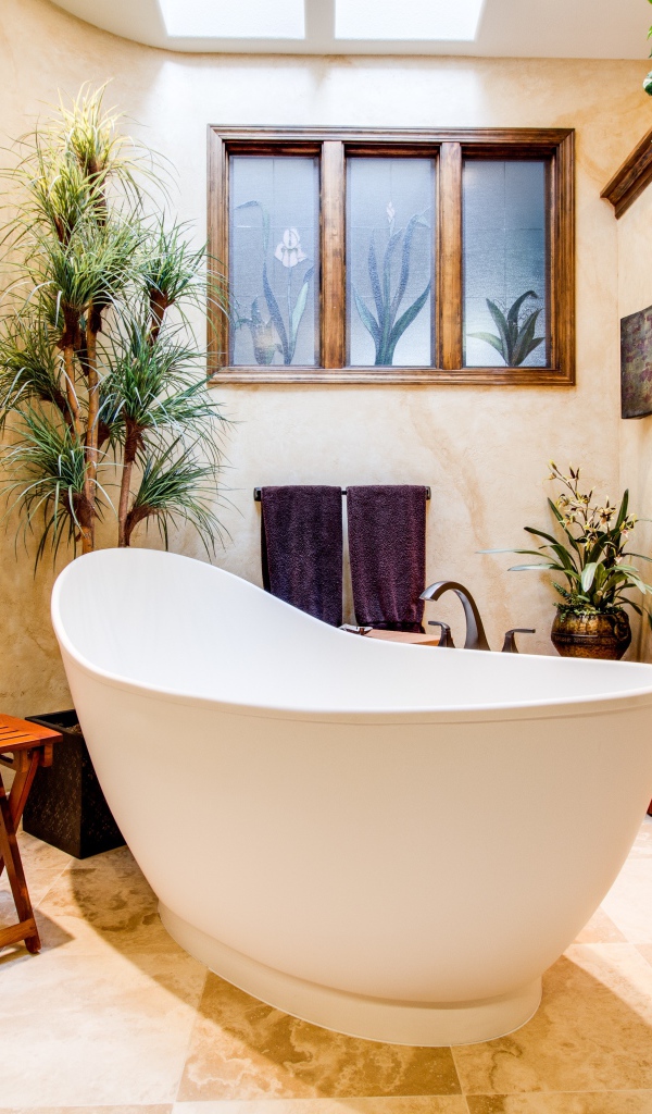 Большая белая ванная в комнате с окном