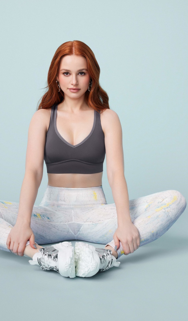 Рыжеволосая американская актриса Мэделин Петш сидит в позе лотоса