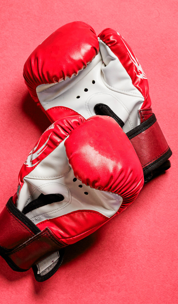 Красные боксерские перчатки на розовом фоне 