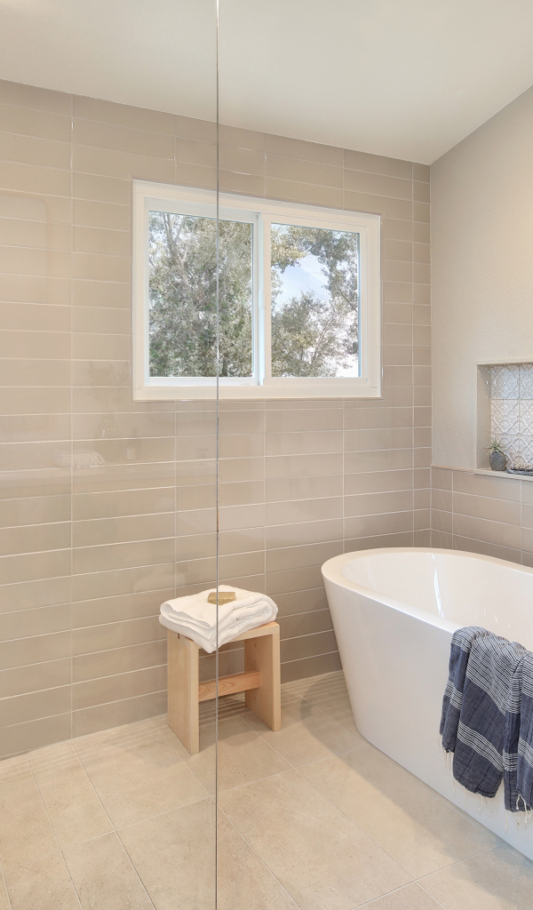 Душевая комната с белой ванной и серыми стенами