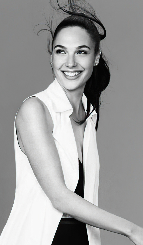 Улыбающаяся актриса Галь Гадот на сером фоне