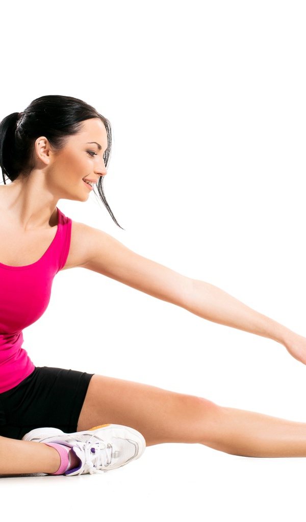Спортивная девушка делает растяжку на белом фоне 