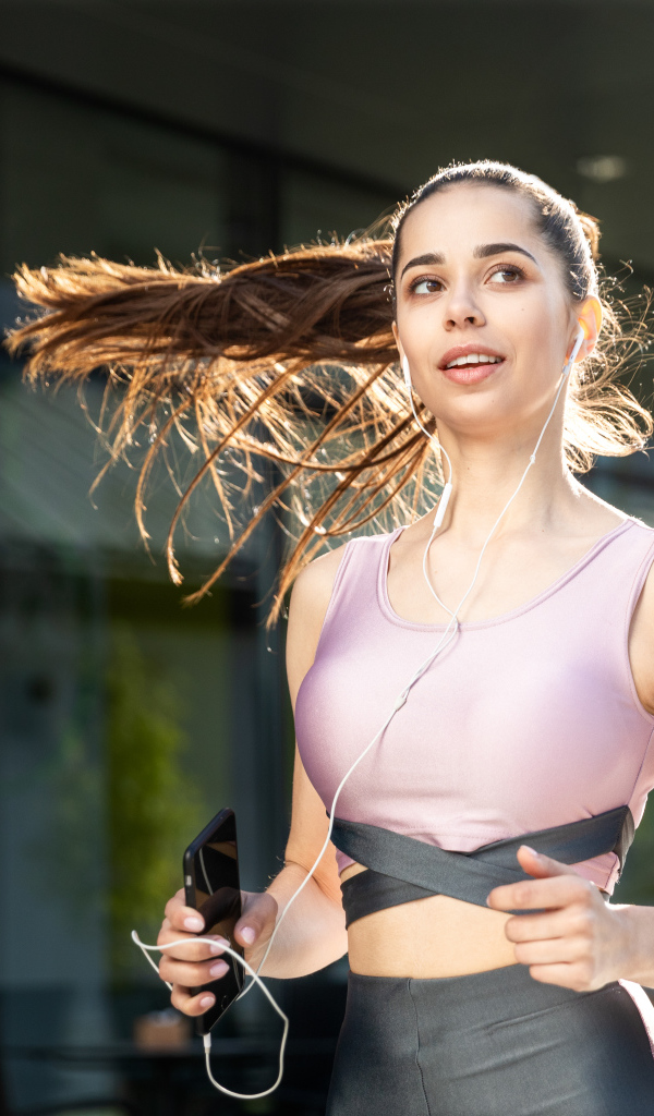 Спортивная девушка занимается бегом на улице