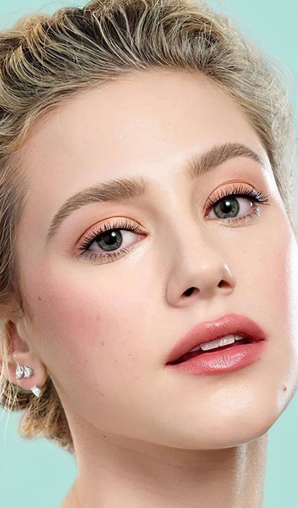 Лицо актрисы Лили Рейнхарт на голубом фоне