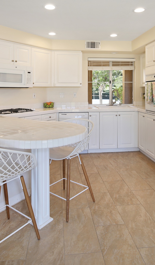 Белая стильная мебель с большим холодильником на кухне