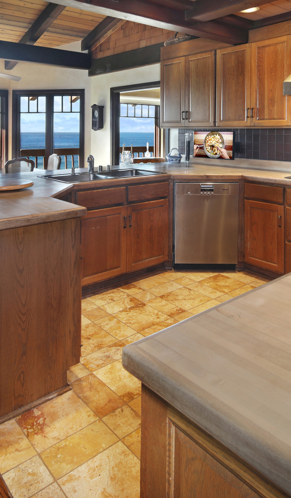Деревянная мебель на кухне с окнами с видом на море