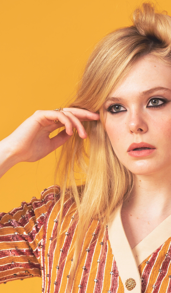 Молодая американская актриса Эль Фэннинг на желтом фоне