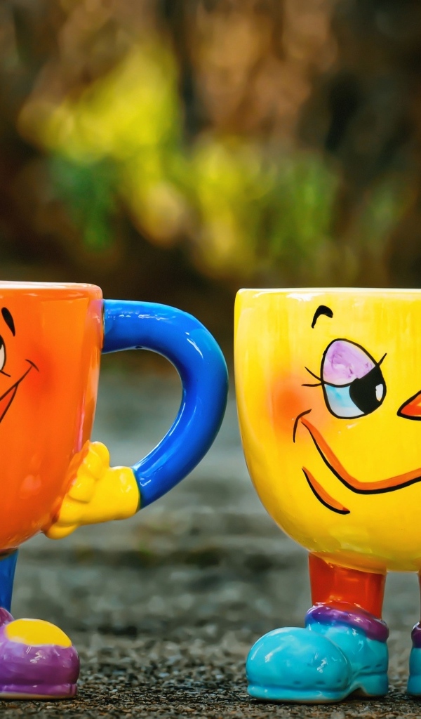Cheerful and sad cups stand on the asphalt