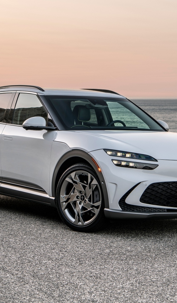 Белый автомобиль Genesis GV60, 2023 года на пляже