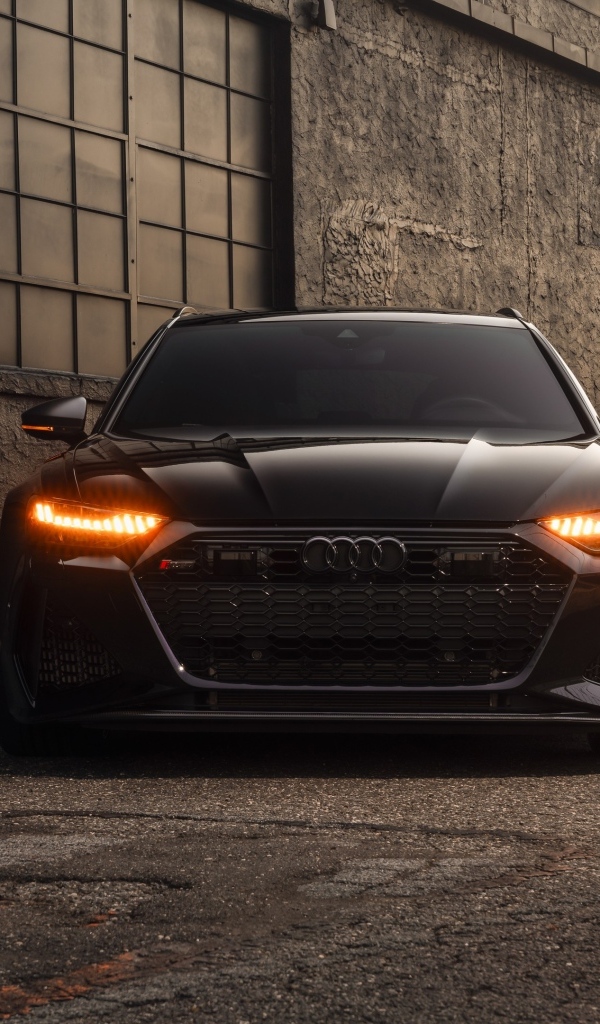 Черный автомобиль Audi RS7 у стены