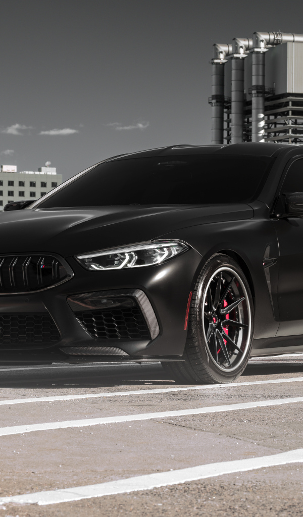 Черный автомобиль BMW M8 на стройке