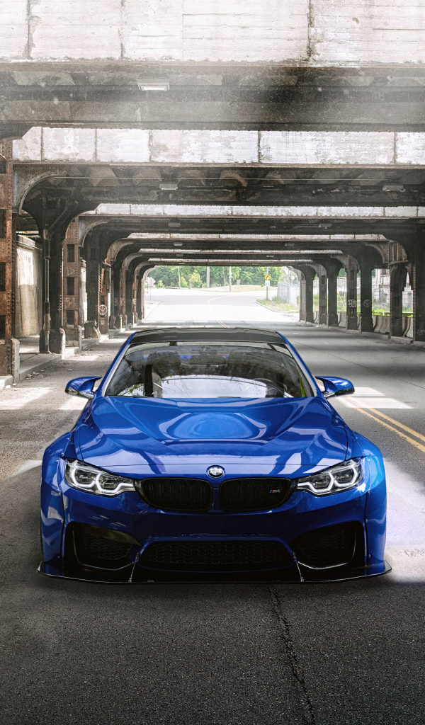 Синий автомобиль BMW M4 под мостом