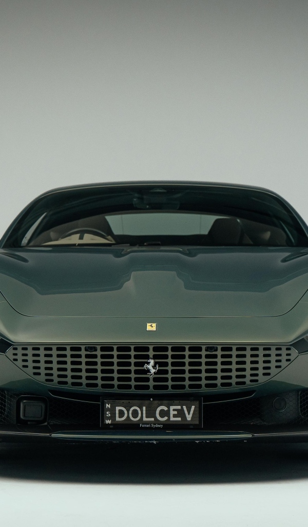 Автомобиль Ferrari Roma на сером фоне вид спереди