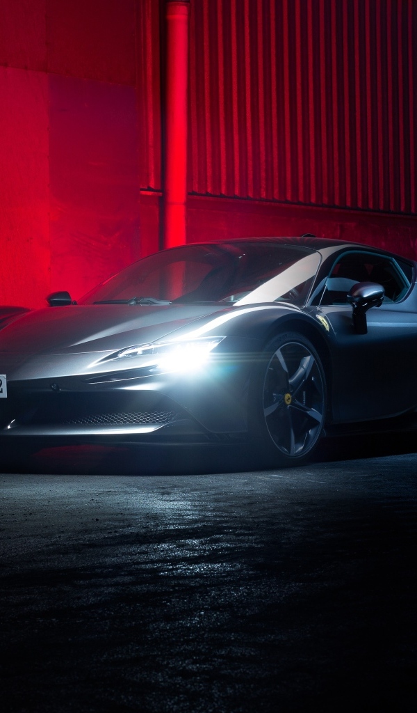 Автомобиль Ferrari SF90 Stradale с включенными фарами на красном фоне