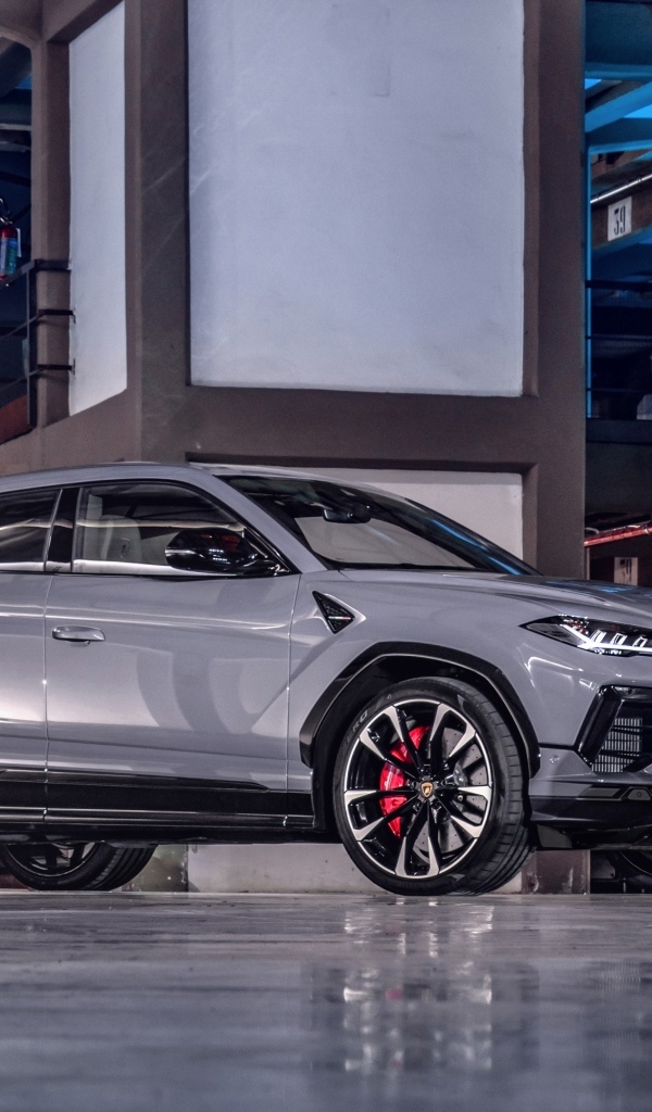Серебристый автомобиль Lamborghini Urus S в здании