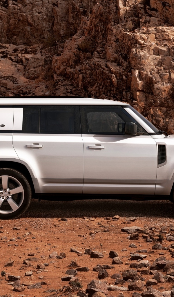 Белый внедорожник Land Rover Defender 130 в горах