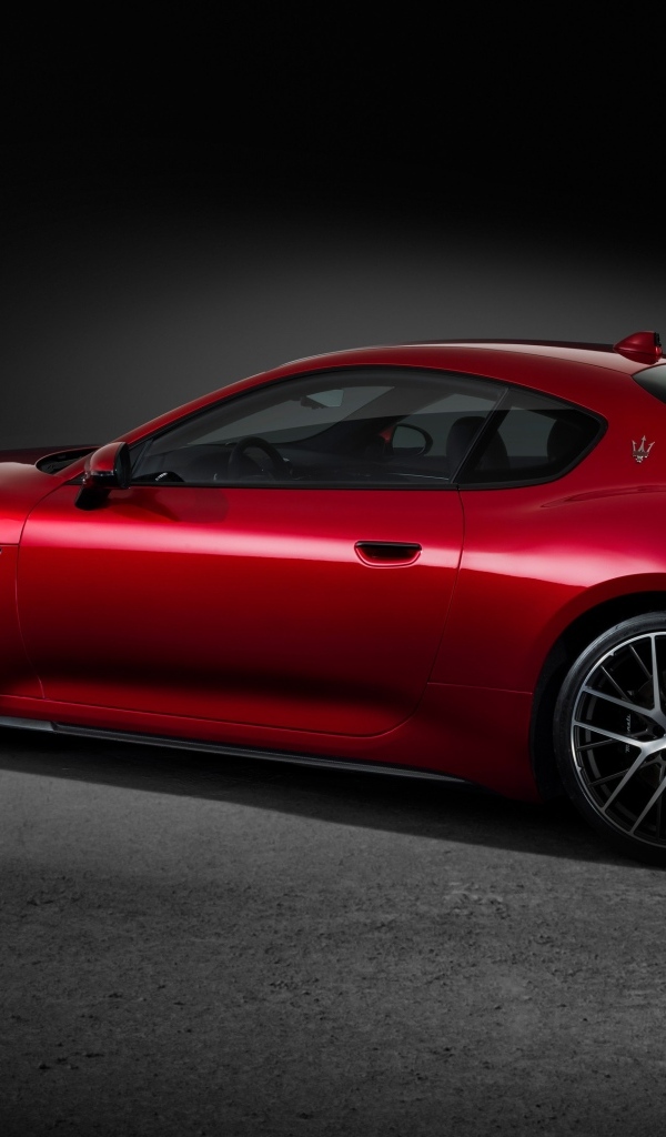 Красный автомобиль Maserati GranTurismo Trofeo 2023 на сером фоне