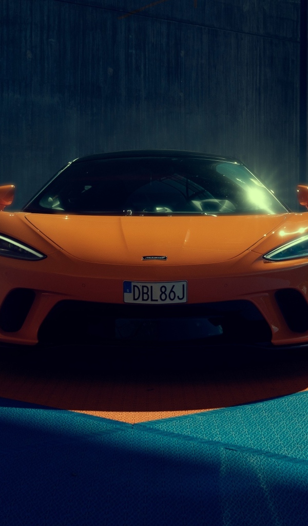 Оранжевый автомобиль McLaren GT вид спереди