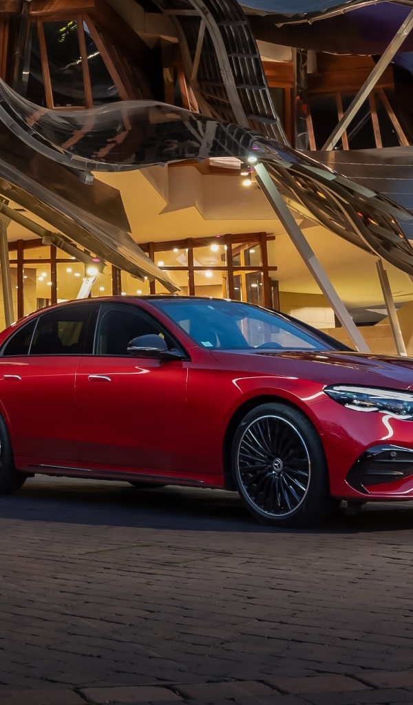 Красный автомобиль Mercedes-Benz E 220 D AMG Line у здания