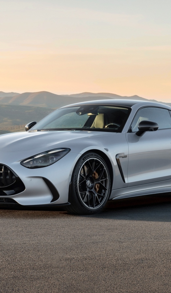 Серебристый автомобиль Mercedes-AMG GT 63 4MATIC+ 2023 года на фоне гор