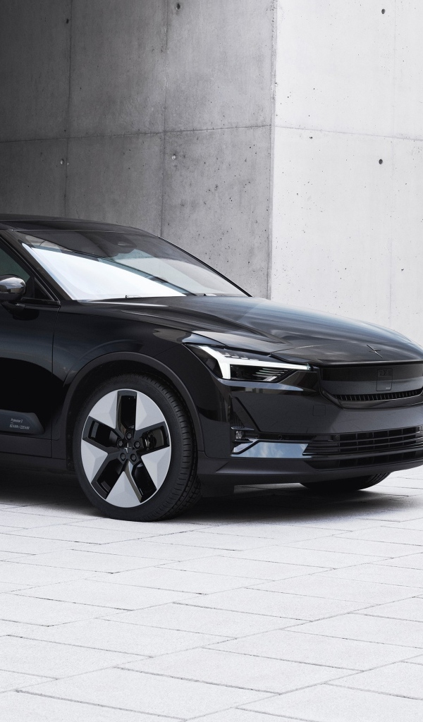 Черный автомобиль Polestar 2 2023 года у серой стены