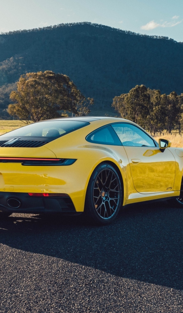 Желтый автомобиль Porsche 911 Carrera GTS вид сзади