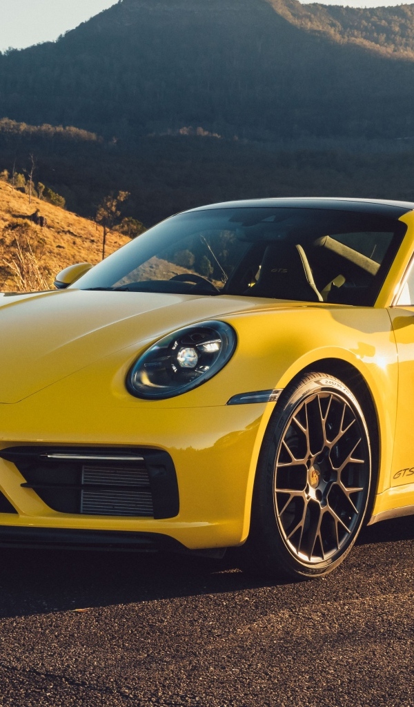 Желтый быстрый автомобиль Porsche 911 Carrera GTS вид спереди