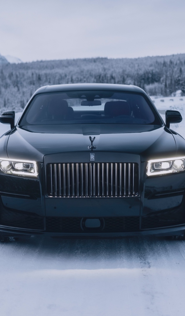 Черный автомобиль Rolls-Royce Black Badge Ghost  на зимней дороге