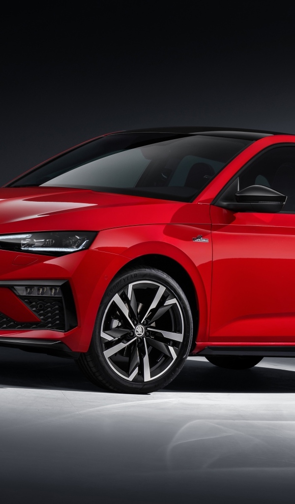 Красный автомобиль Skoda Scala Monte Carlo 2023 года на сером фоне