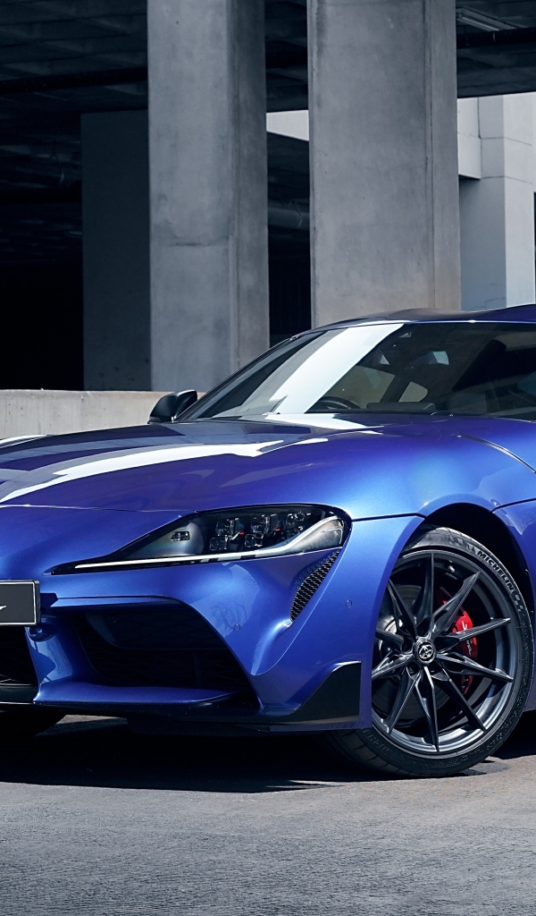 Синий автомобиль Toyota GR Supra 3.0 MT 2023 года у серого здания
