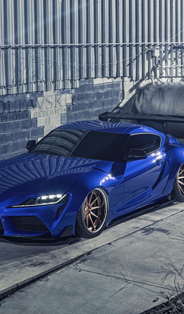 Синий спорткар Toyota Supra Luxury у здания