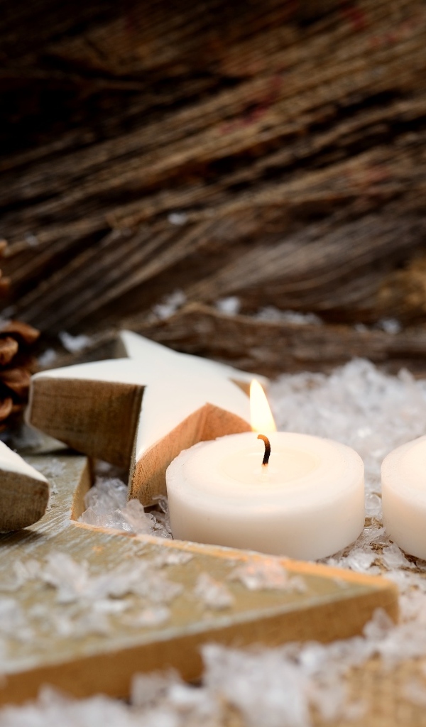 Две зажженные свечи, шишки и звезды