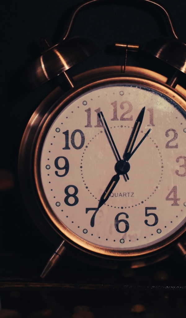 Большой будильник показывает семь часов