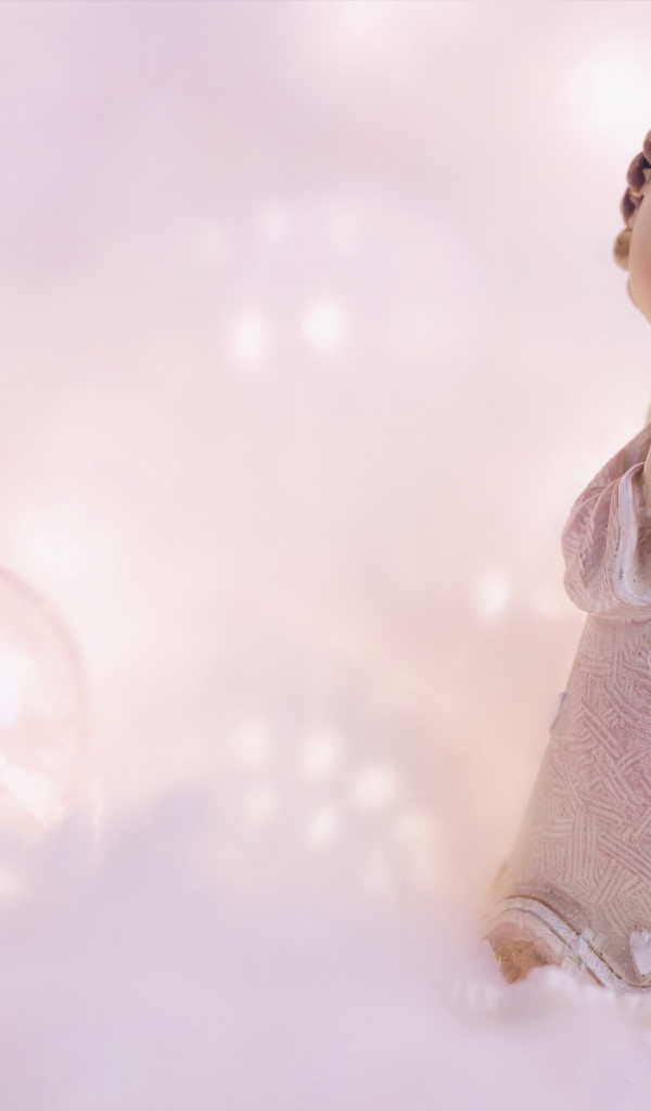 Статуэтка ангела на розовом фоне