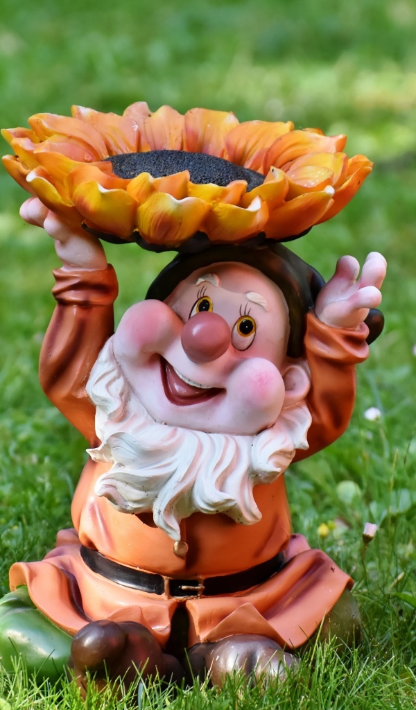 Садовая фигура гном за зеленой траве