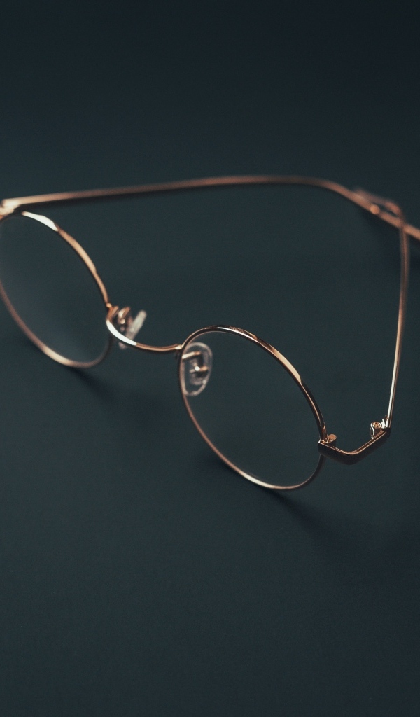 Очки лежат на серой поверхности