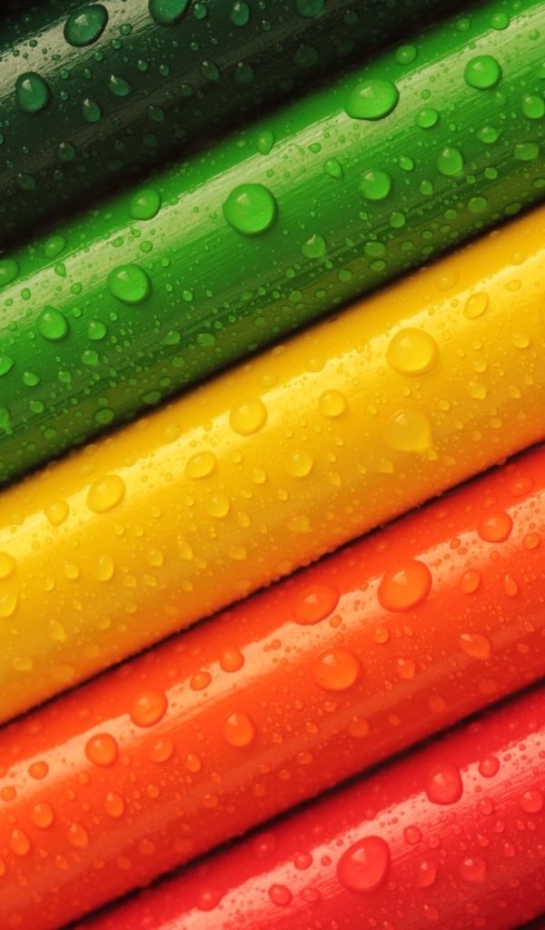 Разноцветные карандаши в каплях воды