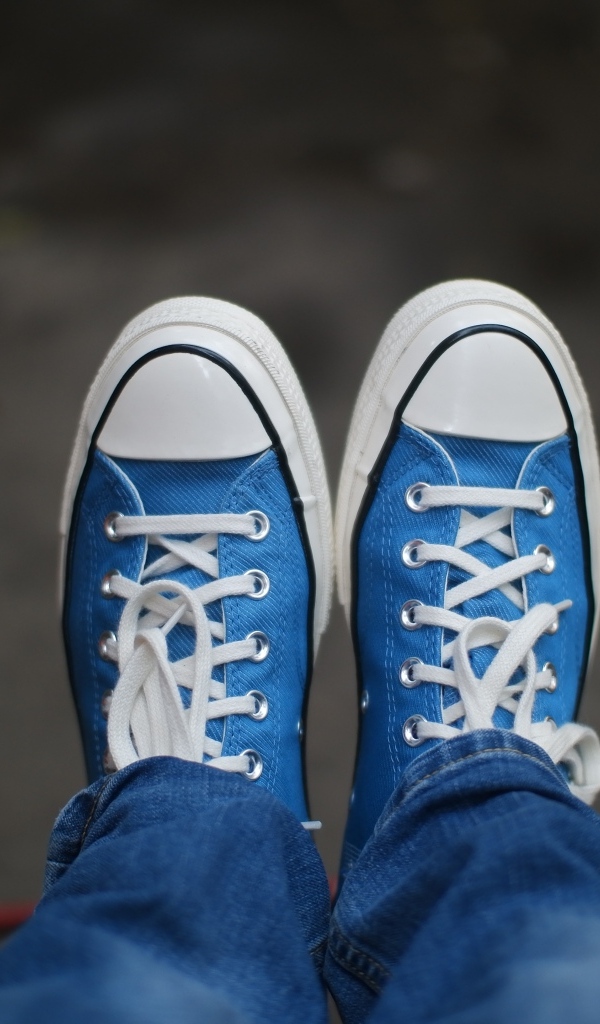 Кеды на ногах в джинсах