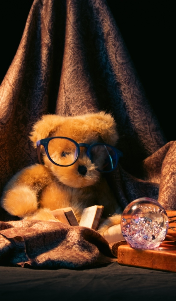 Игрушечный медвежонок с книгами на черном фоне