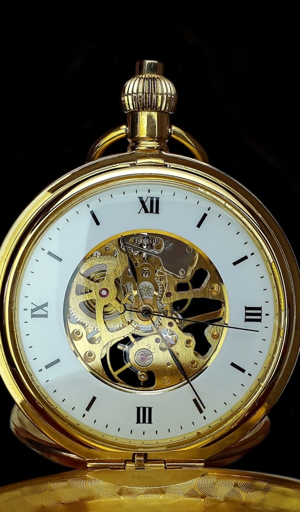 Старинные золотые карманные часы на черном фоне