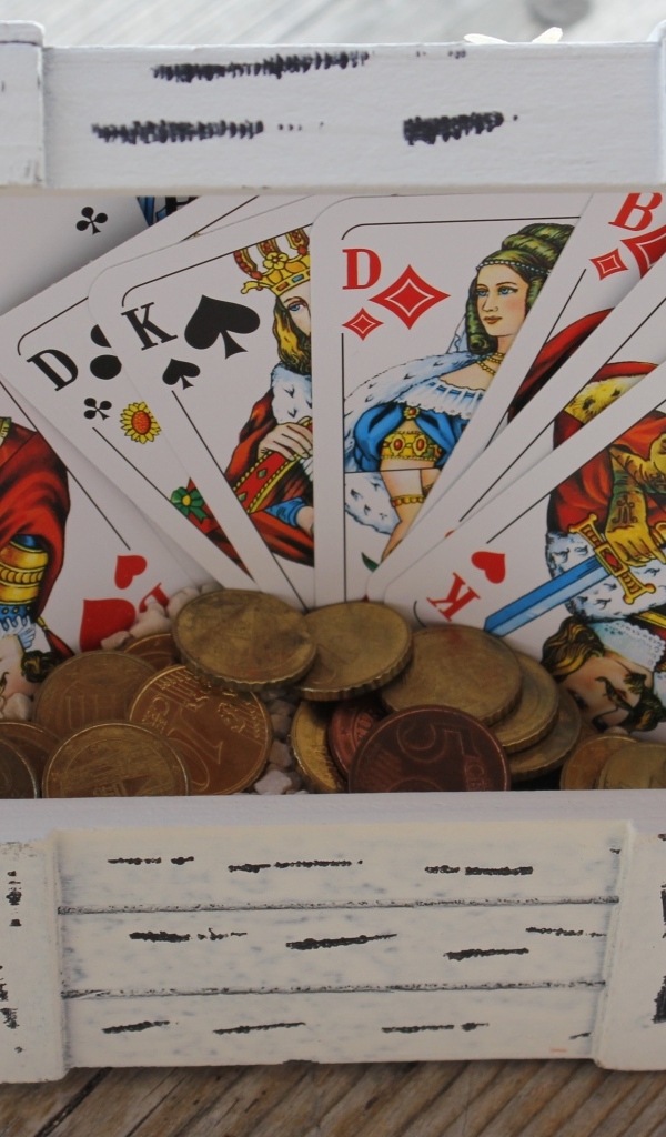 Колода карт и монеты в деревянной шкатулке