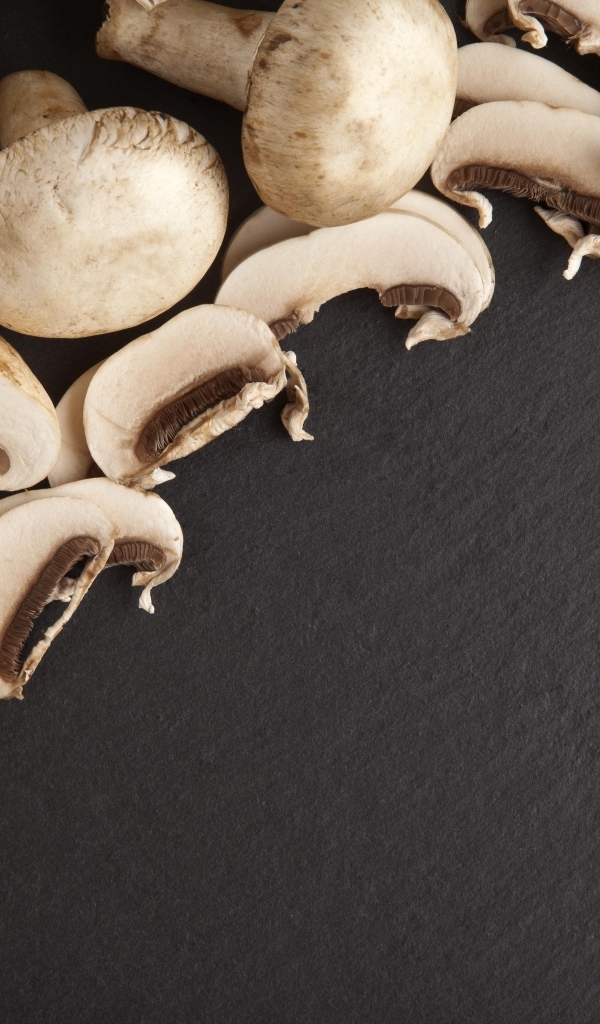 Аппетитные свежие шампиньоны на сером столе