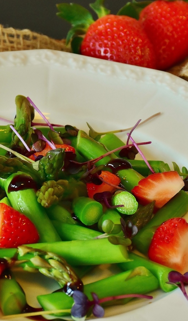 Спаржа в тарелке с клубникой