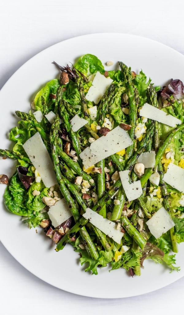 Спаржа на белой тарелке с сыром