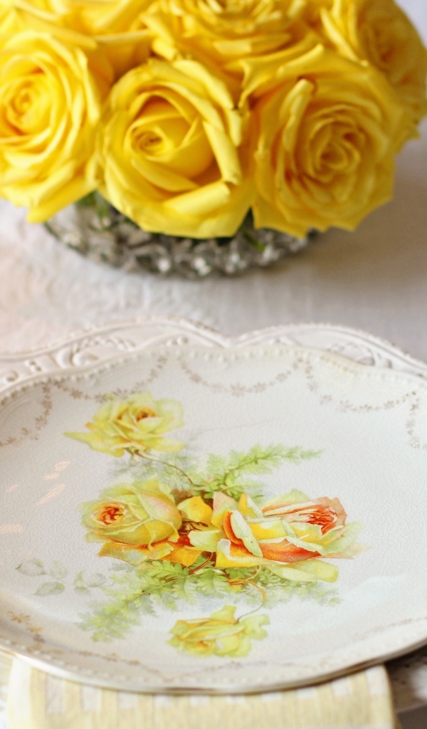 Красивая тарелка на столе с розами 