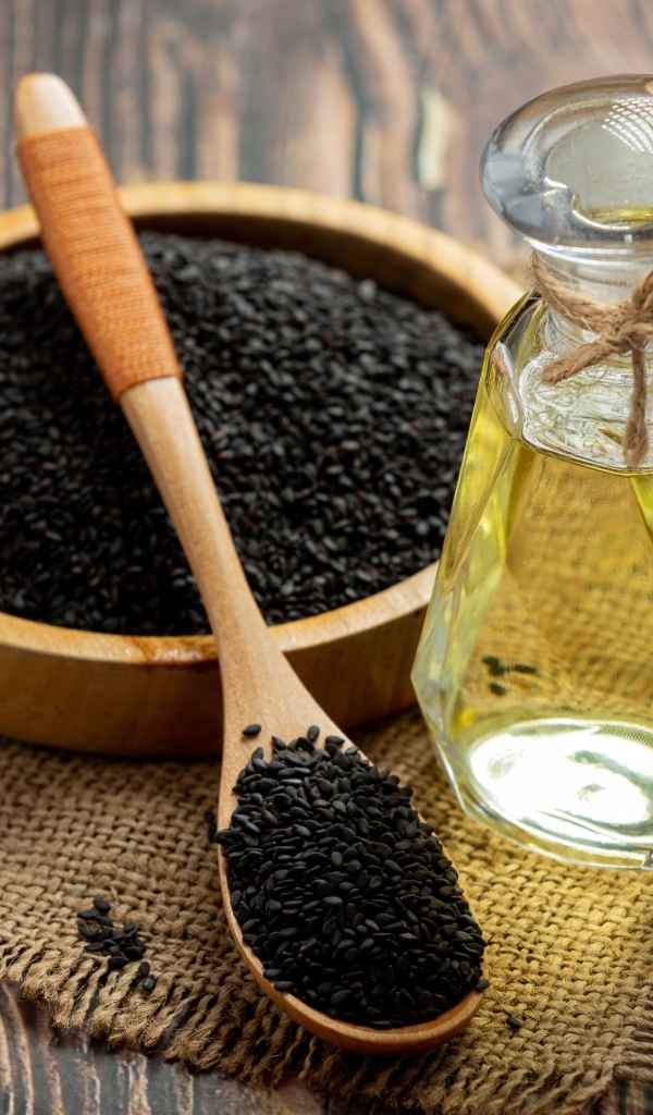 Черные семена на столе с маслом