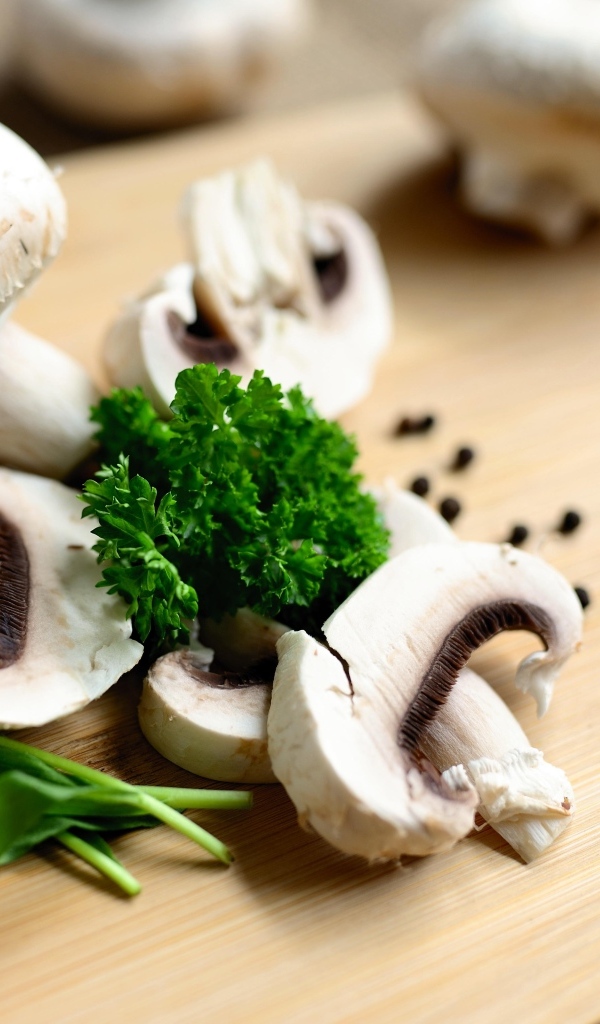 Шампиньоны с петрушкой на разделочной доске